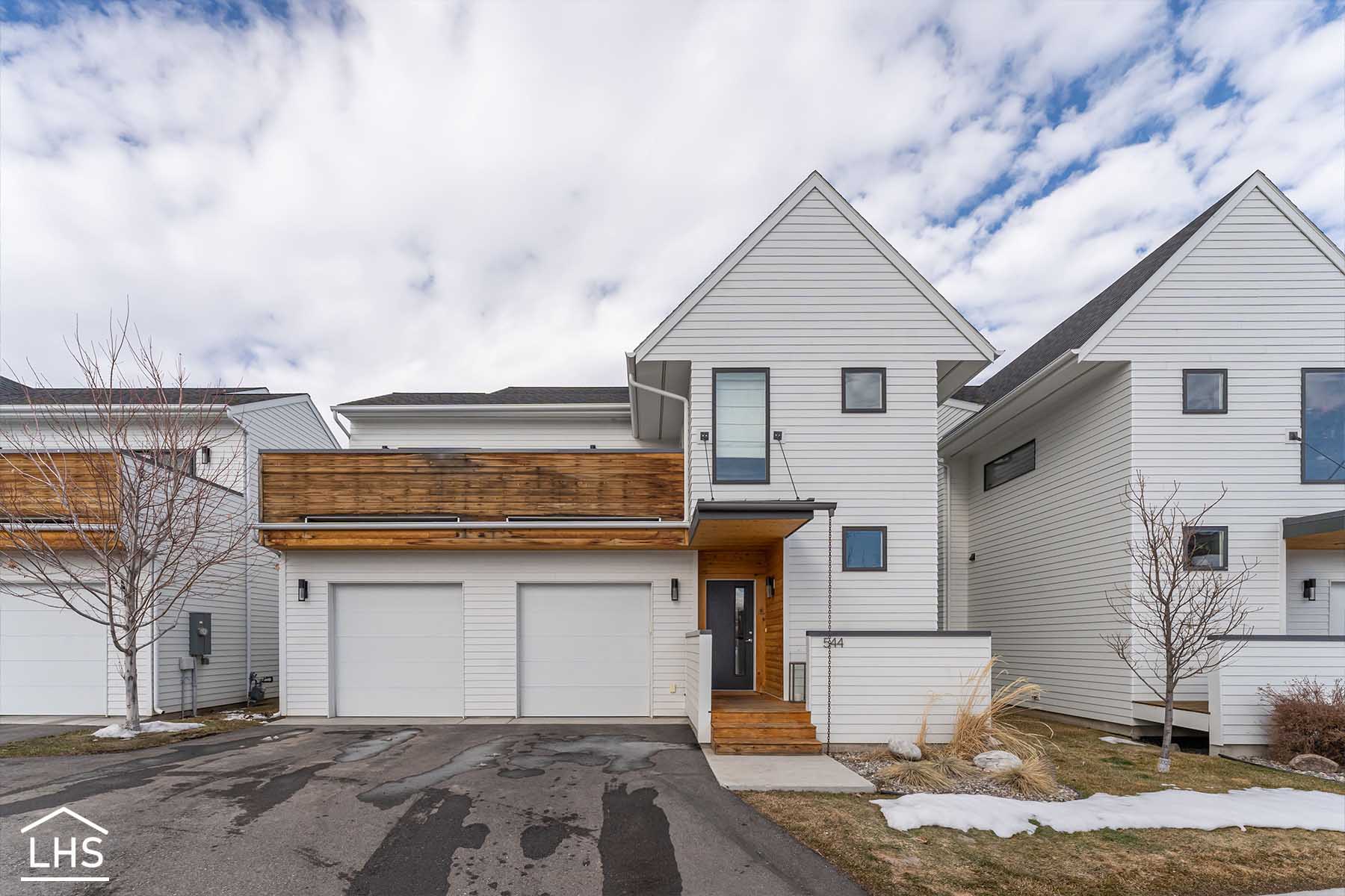 A plain house exterior with an unkempt yard and a cloudy sky.